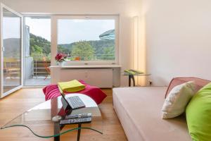 a living room with a couch and a laptop on a glass table at Traumblick in Bad Liebenzell