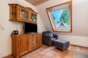 a room with a tv and a chair and a window at Igelbau in Wolfach