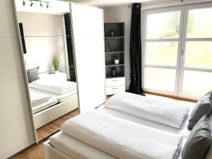 a bedroom with two beds and a large mirror at Osserblick Galerie in Lohberg