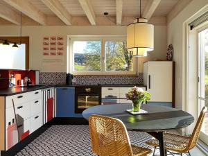 a kitchen with a table with a vase of flowers on it at Ferienwohnung Waldmeisterzimmer in Sankt Peter +12 photos