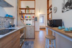 a kitchen with a counter and a bar with a tv at Villa Nonna Anna a Plemmirio in Syracuse