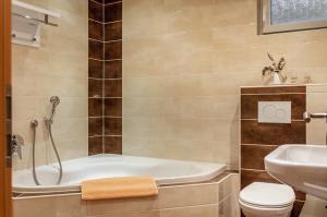 a bathroom with a tub and a toilet and a sink at Ferienwohnung Weinberg in Markt Einersheim +18 photos