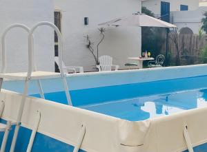 a pool with chairs and a table and an umbrella at Villa Nonna Anna a Plemmirio in Syracuse