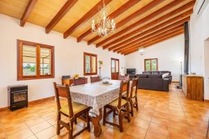 a dining room with a table and chairs and a couch at Casita Rafal Roig in Maria de la Salut