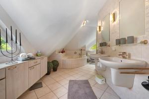 a bathroom with a sink and a tub and a toilet at Ferienhaus im Grünen in Harsefeld +32 photos