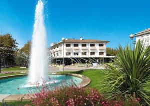 a fountain in a park in front of a building at Hotel Genzianella in Cervia