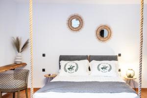 a bedroom with a hanging bed with two mirrors on the wall at Mont' Rock villas 2 in Posidhonía +21 photos