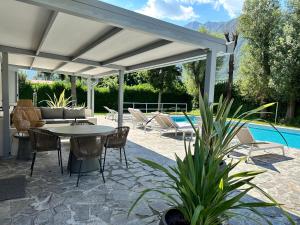 a patio with a table and chairs and a pool at Villa Romantica Lake Idro in Bagolino