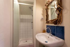 a bathroom with a sink and a shower with a mirror at Gite 8 personnes in Bégard +16 photos