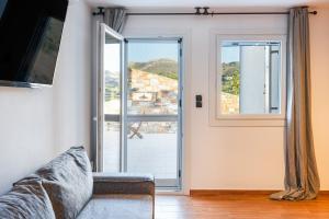 a living room with a couch and a sliding glass door at Mont' Rock villas 2 in Posidhonía