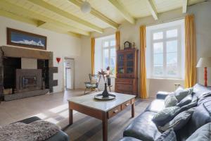 a living room with a couch and a fireplace at Gite 8 personnes in Bégard