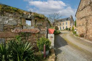 an old stone building with a sign on it at Gite 8 personnes in Bégard
