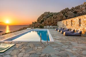 a pool with a view of the ocean and the sunset at Mont' Rock villas 2 in Posidhonía