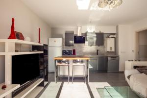 a kitchen and living room with a table and a couch at Appartement Evasion in Marseille +14 photos