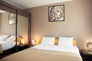 a bedroom with two beds and a painting on the wall at Appartement Evasion in Marseille