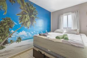 a bedroom with a large bed with a palm tree mural at Penthouse con Jacuzzi in Costa Teguise