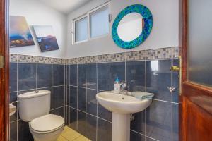 a bathroom with a toilet and a sink and a mirror at Penthouse con Jacuzzi in Costa Teguise +19 photos