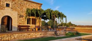 a stone house with a tree and a patio at Son Garrot in Santanyi