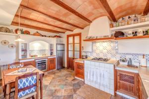 a large kitchen with wooden cabinets and a table at Son Garrot in Santanyi +36 photos
