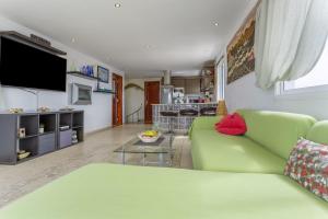 a living room with a green couch and a table at Penthouse con Jacuzzi in Costa Teguise