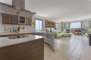a kitchen and a living room with a couch at Penthouse con Jacuzzi in Costa Teguise