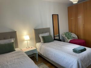 a bedroom with two beds and a table with a lamp at Helsinki Green Retreat in Helsinki