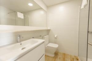 a white bathroom with a sink and a toilet at Son Bou Gardens Plus 2 in Son Bou