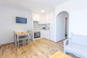 a kitchen and living room with a table and a couch at Son Bou Gardens Plus 2 in Son Bou +15 photos