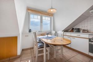 a small kitchen with a wooden table and chairs at Wohnung Hallighof in Honkenswarft +23 photos