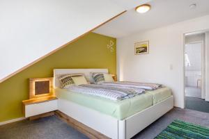 a bedroom with a bed with a green wall at Wohnung Hallighof in Honkenswarft