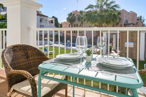 a table with glasses and plates on a balcony at Nerja Vacaciones Apartamentos in Nerja
