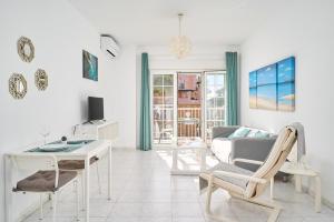 a white living room with a couch and a table at Nerja Vacaciones Apartamentos in Nerja