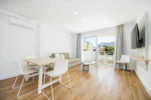 a white living room with a table and chairs at Apartament Massanet 1c in Canyamel