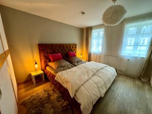 a bedroom with a large bed and two windows at Wohnung In Wolfenbüttel in Wolfenbüttel