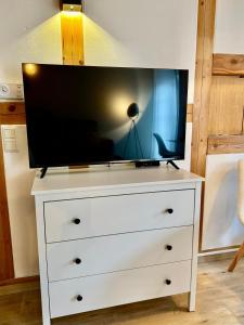 a white dresser with a tv on top of it at Wohnung In Wolfenbüttel in Wolfenbüttel