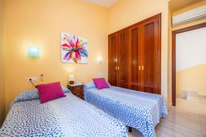 two beds sitting next to each other in a bedroom at Llac D'alcudia in Port d'Alcudia +29 photos