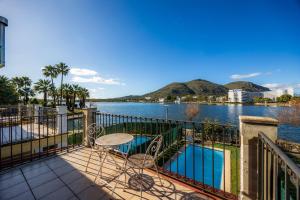 a balcony with a table and a view of the water at Llac D'alcudia in Port d'Alcudia