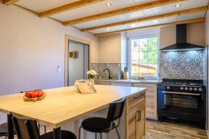 a kitchen with a wooden island with a bowl of fruit at Gîte Les 3 Cerfs - 3 étoiles in Plainfaing