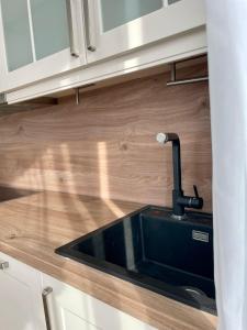 a kitchen with a black sink and wooden cabinets at Max Haus 2 in Karlstadt +12 photos