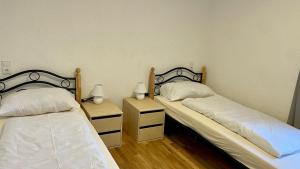 two twin beds in a room with two night stands at Max Haus 2 in Karlstadt