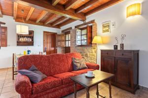 a living room with a red couch and a table at El Ferre in Nava