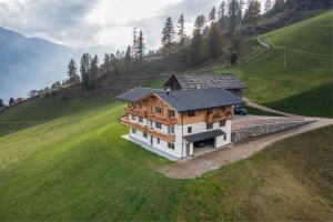 a house on top of a green hill at Oberhaushof in Santa Valpurga