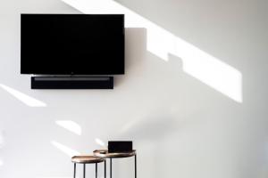 a flat screen tv hanging on a wall with two stools at Villa Venza , Salento in Otranto