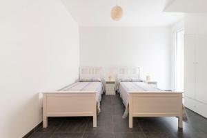 two beds in a room with white walls at Villa Venza , Salento in Otranto +16 photos