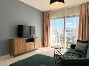 a living room with a tv and a large window at Nothern Cyprus Caesar Resort & Spa Collection Pools & Long Beach in Aglantzia