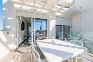 a dining room with a white table and chairs on a balcony at Villa Venza , Salento in Otranto
