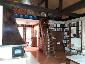 a living room with a staircase and a fireplace at Ferienhaus mit Schwimmhalle in Burgthann