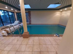 a pool in a house with a ceiling at Ferienhaus mit Schwimmhalle in Burgthann