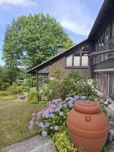 a large pot sitting outside of a house with flowers at Ferienhaus mit Schwimmhalle in Burgthann