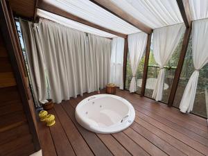 a large white tub in a room with windows at A Cabanha in Caçador +56 photos